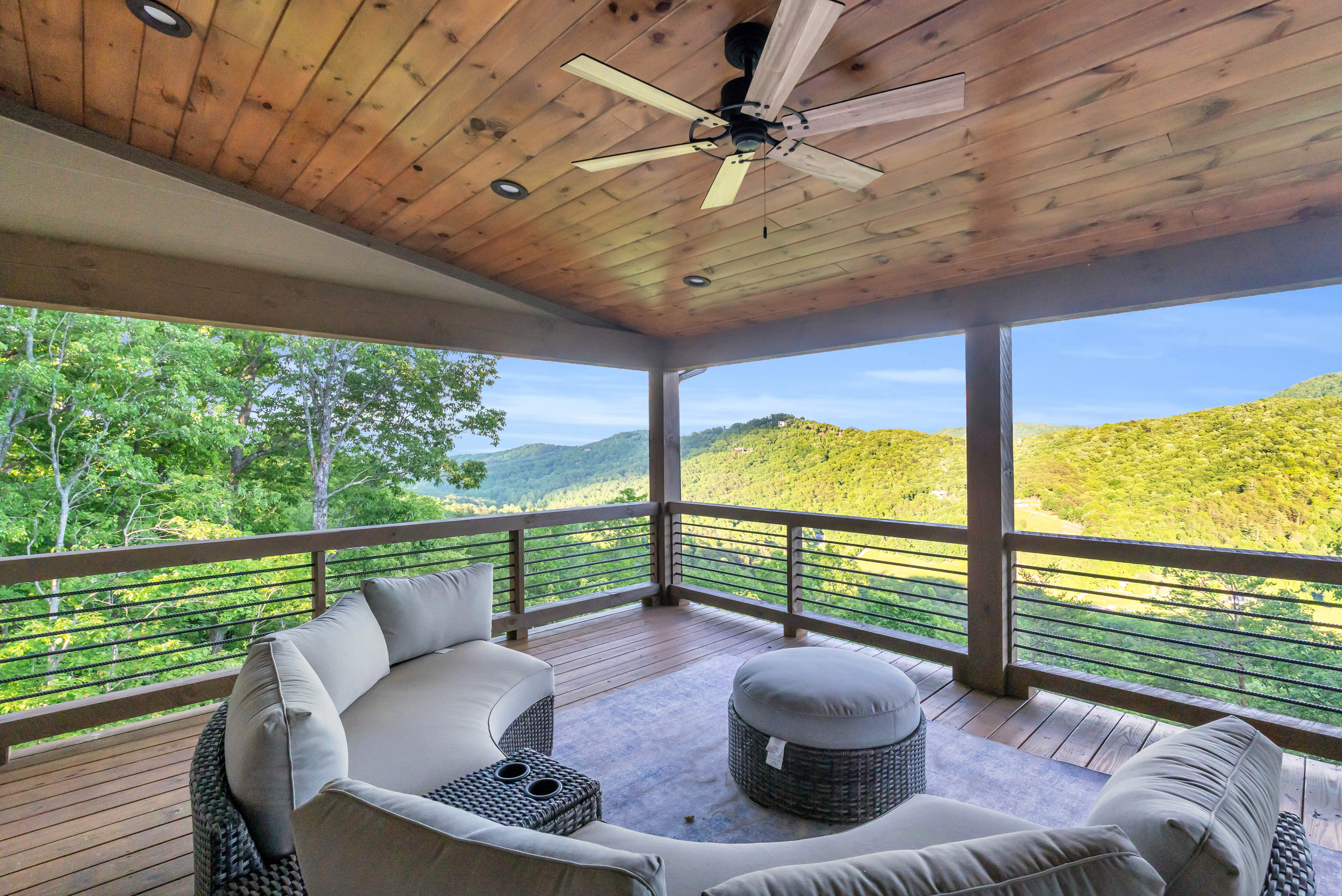 Covered porch with outdoor seating overlooking layered Blue Ridge mountains