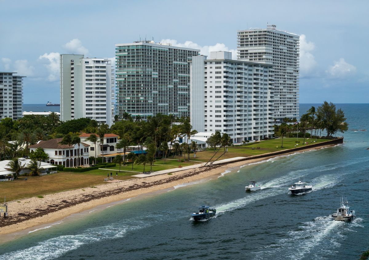 Aerial view of Fort Lauderdale waterfront high-rise condominium towers with boats moored along the channel below