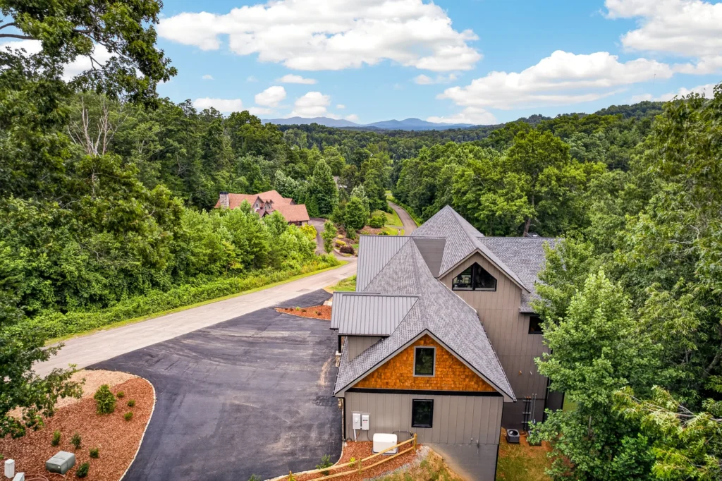 Aerial view of a mountain home with layered ridgelines in the distance