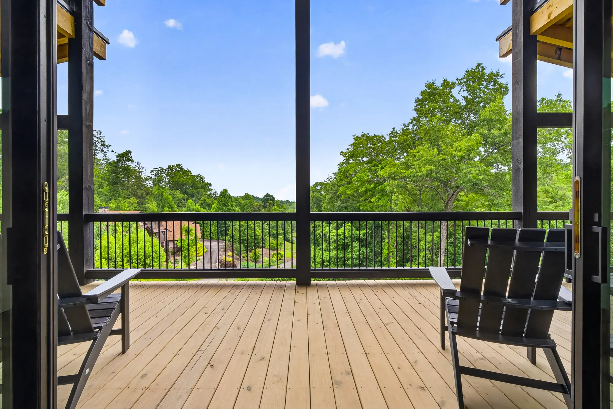 Covered deck with two chairs facing a long wooded mountain view