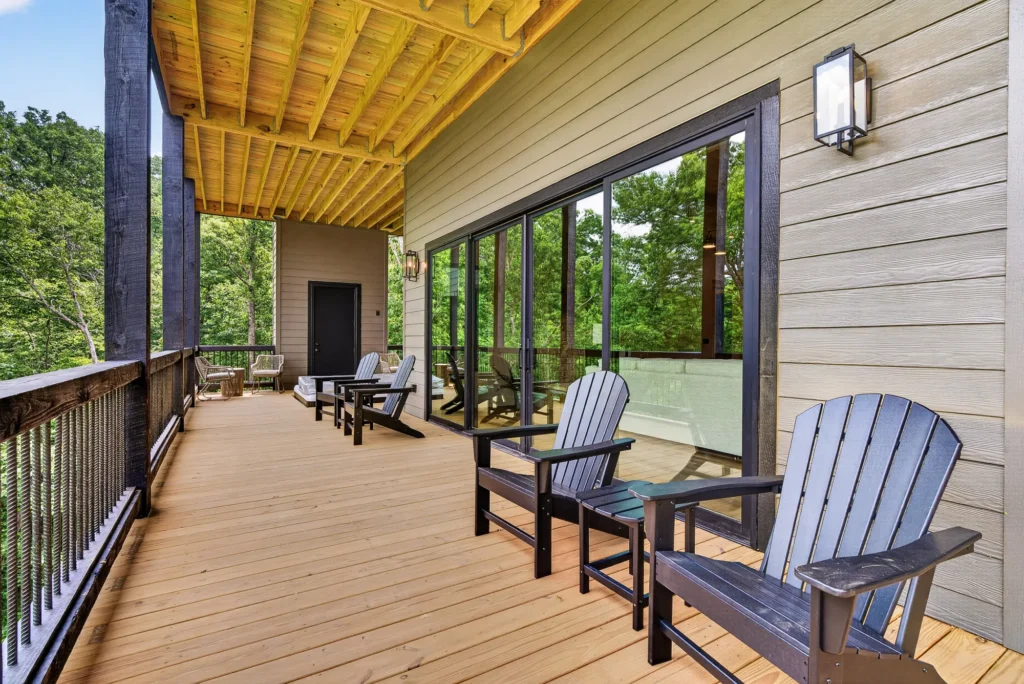 Adirondack chairs on a covered porch overlooking the trees