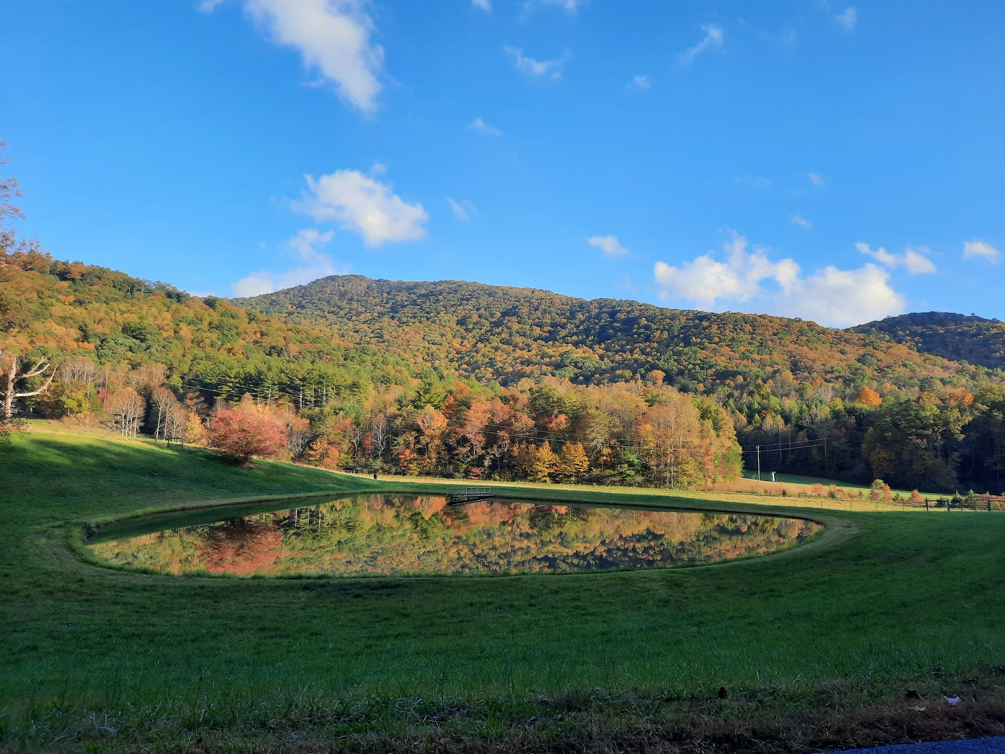 Open pasture and pond beneath forested mountains in Blue Ridge, Georgia