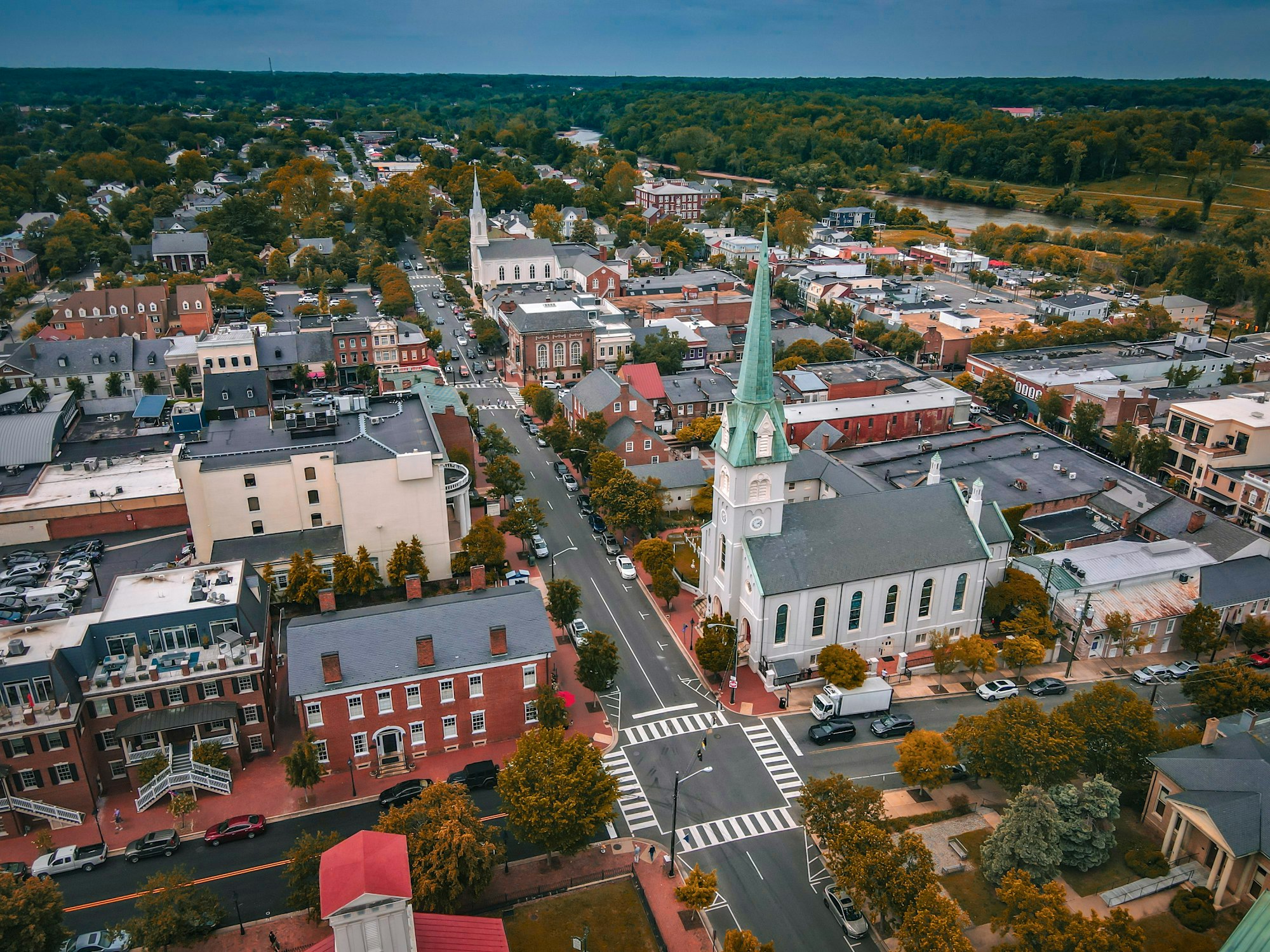 Aerial view of a historic small town beside a tree-lined river