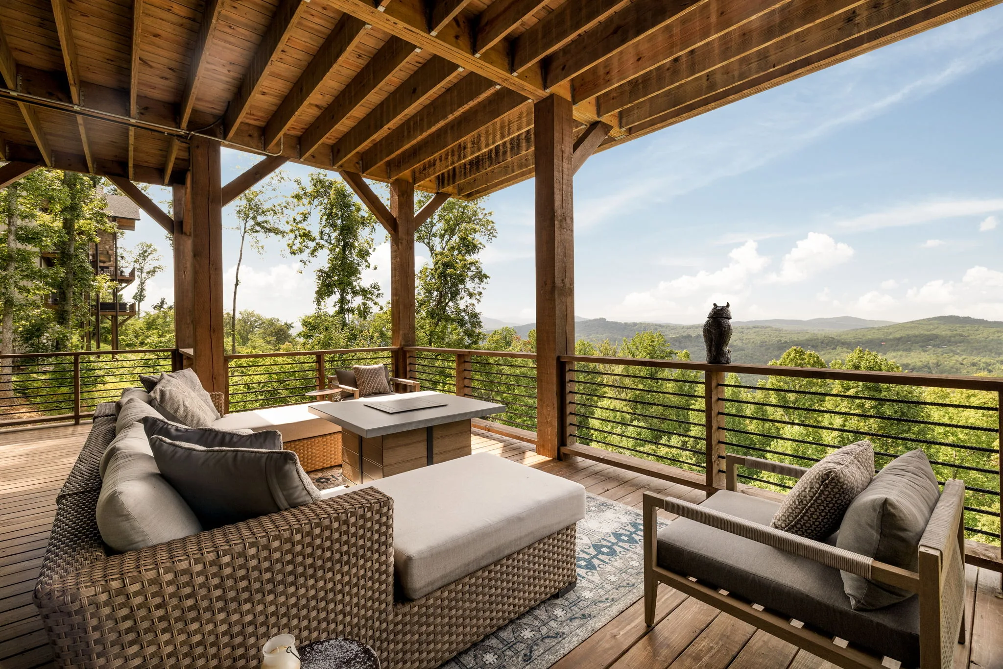 Upper deck lounge with fire table and long-range mountain view