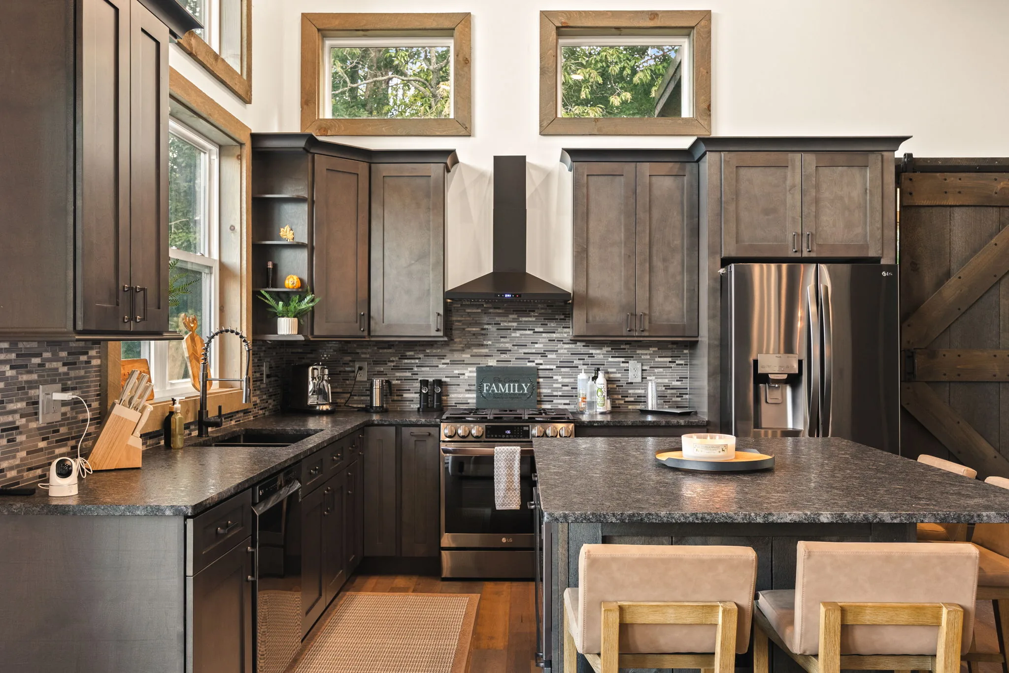 The working run of the kitchen — apron sink under the window, stainless refrigerator and a coffee station at the end.