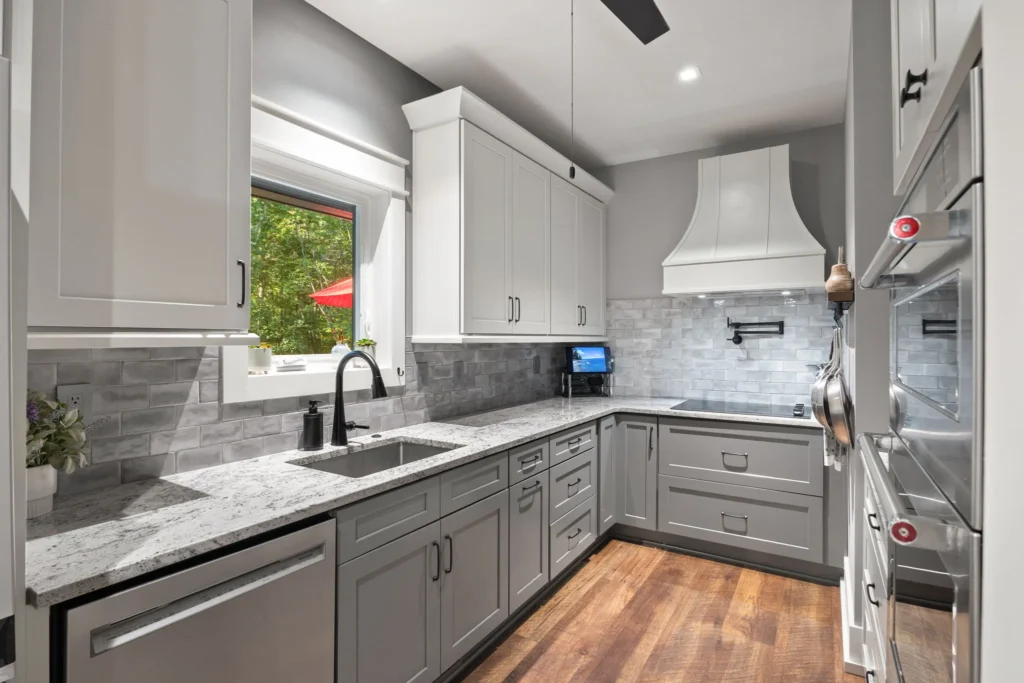 Full layout: granite counters, tile backsplash, vent hood, wall ovens