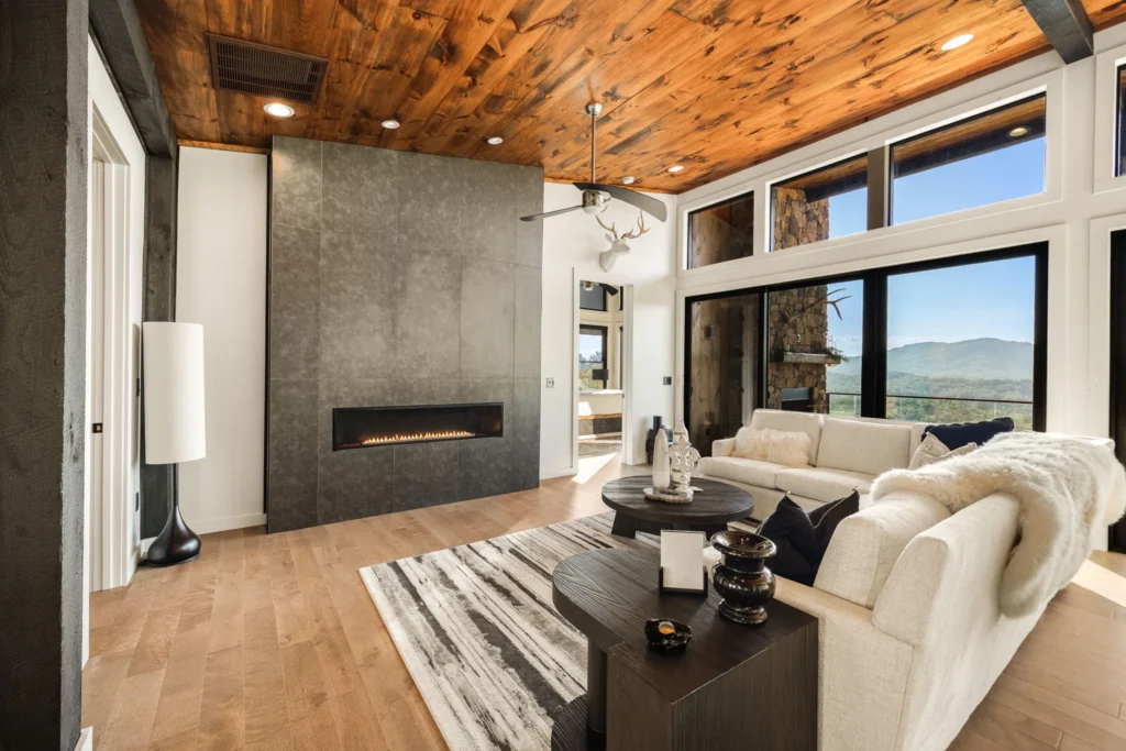 Great room with a linear gas fireplace set into a full-height tile wall under a knotty-pine cathedral ceiling