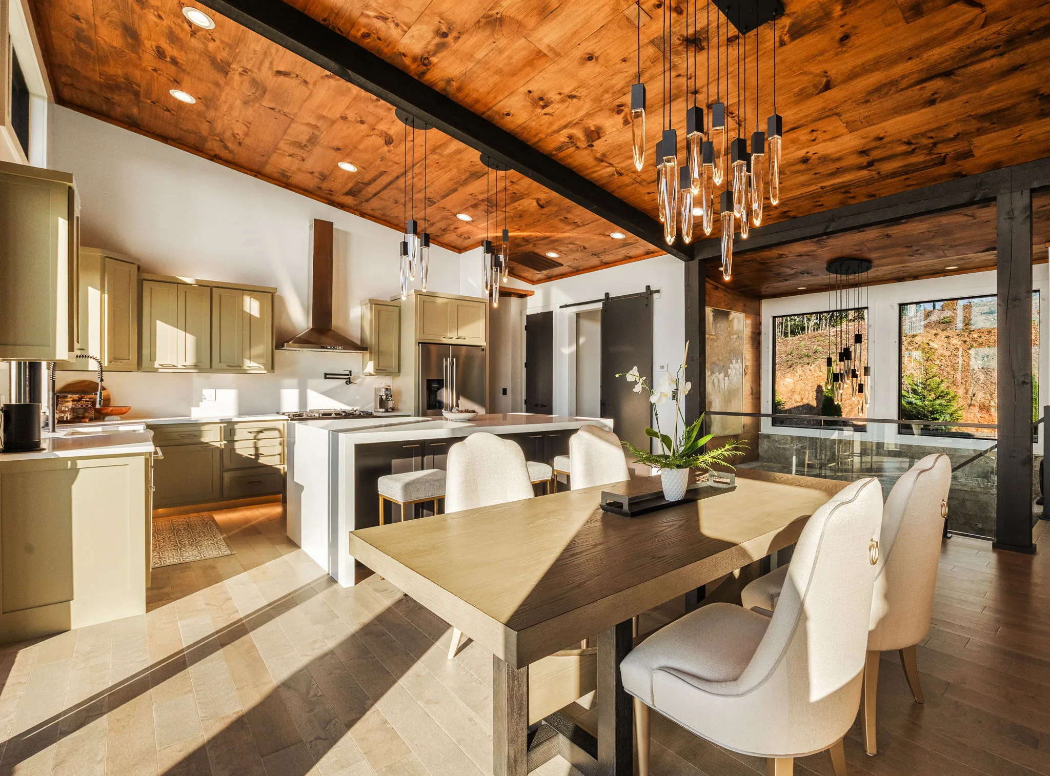 Kitchen from the dining side, pendant cluster and clerestory windows above