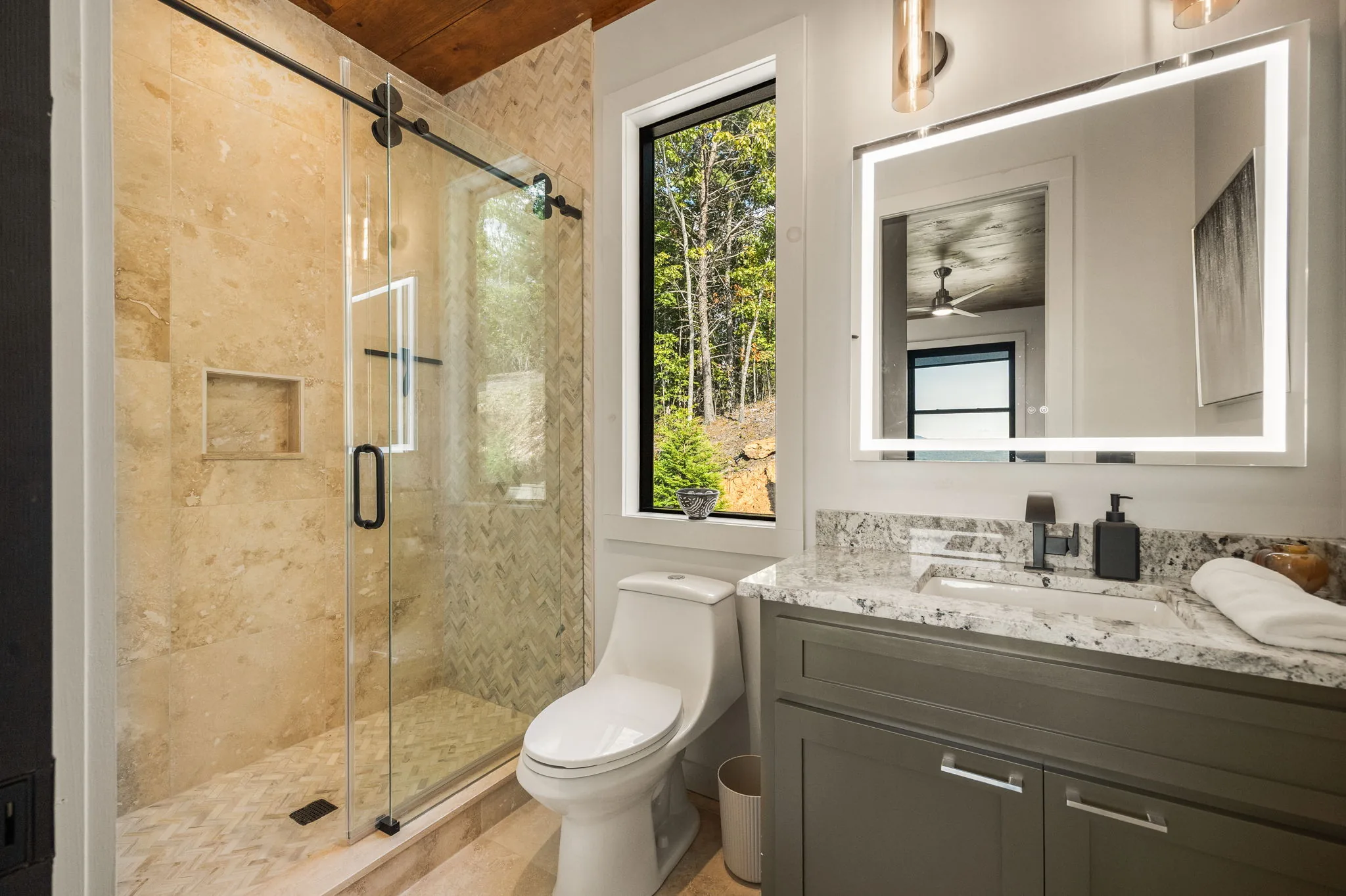 Guest bath with a travertine herringbone shower and granite vanity