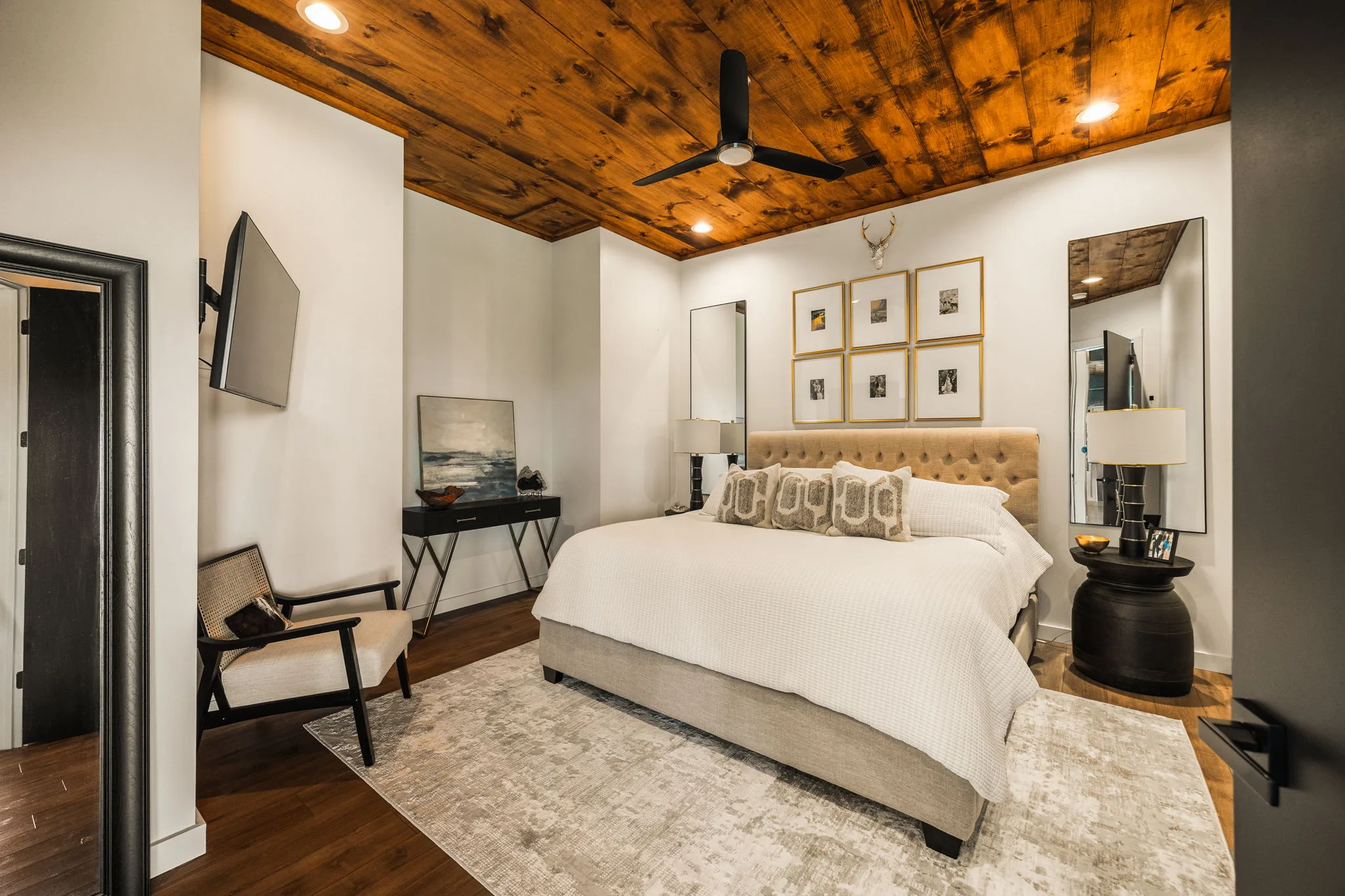 Third bedroom with a tufted headboard and gallery wall