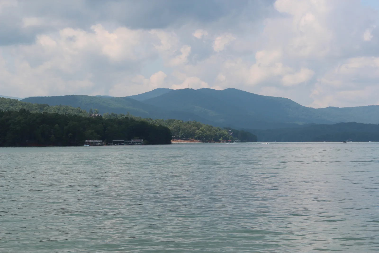 Lake Blue Ridge from Morganton Point in July, with boathouses and docks along a wooded shoreline and the North Georgia mountains behind